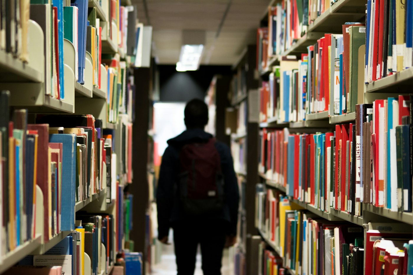 Pelajar berjalan di lorong perpustakaan